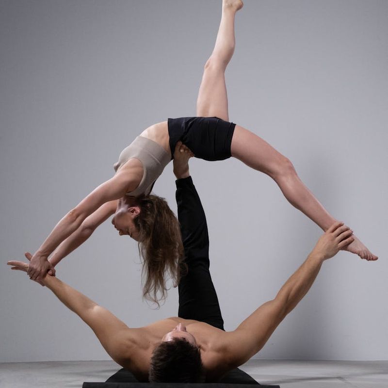 Woman performing a challenging balance yoga pose indoors.
